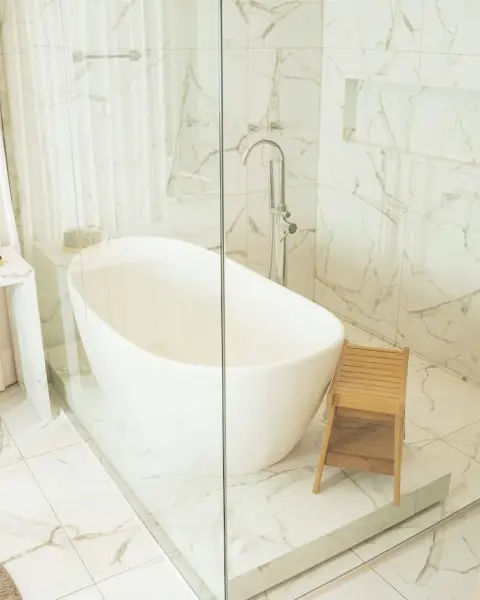 Bathroom with a tub and stool