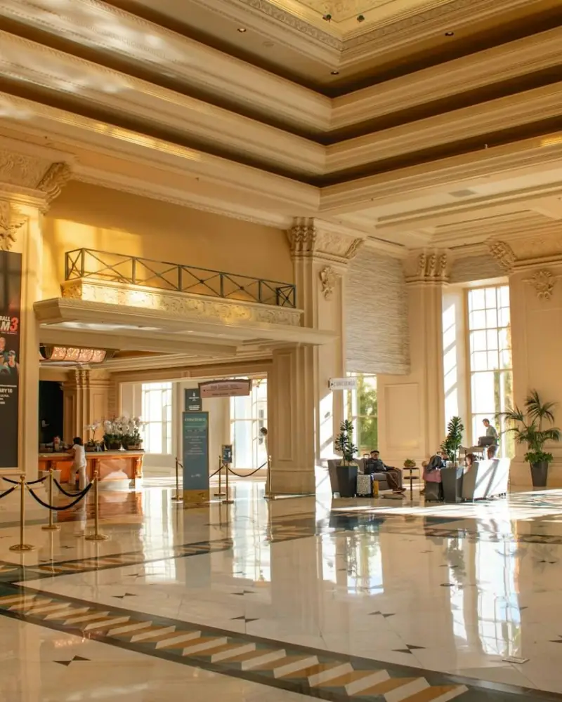 A grand hotel lobby filled with sunlight