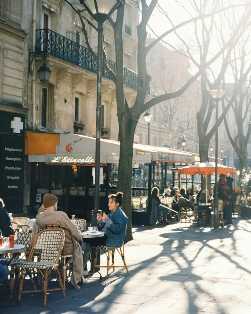 People at tables outside a café