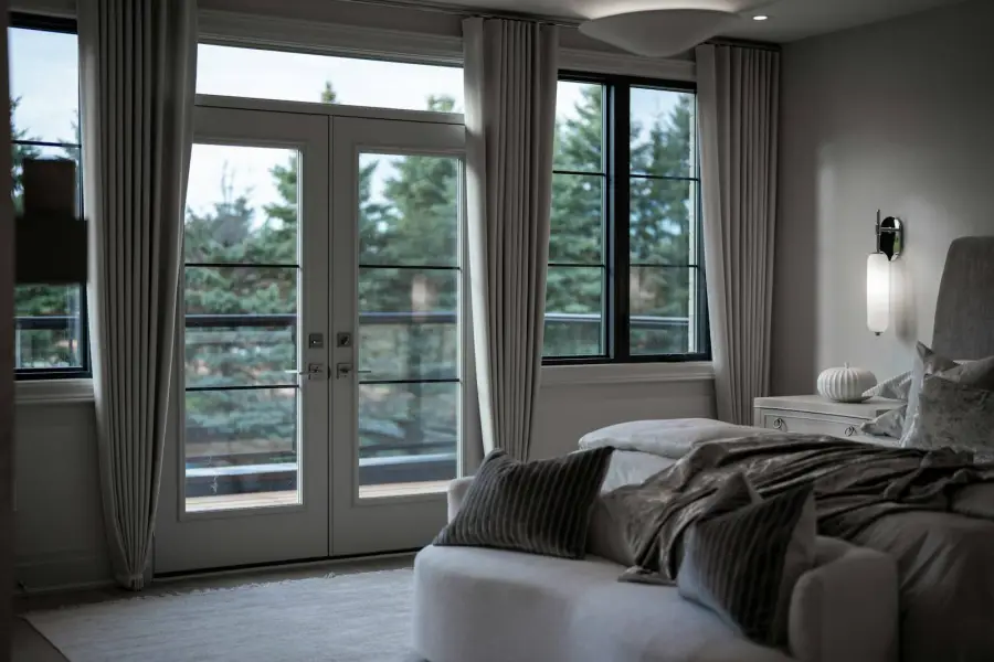 Bedroom with windows onto a forest