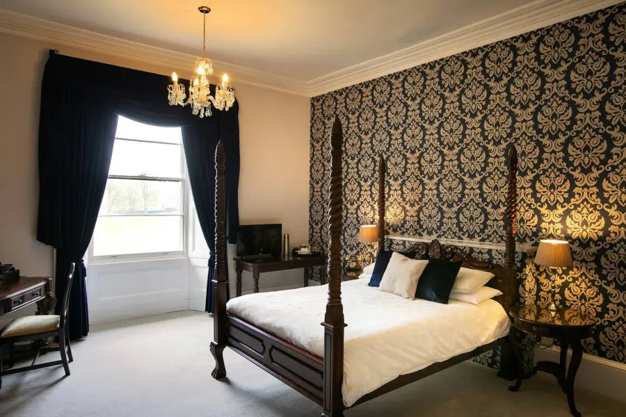 Four-poster bed and ornate wallpaper