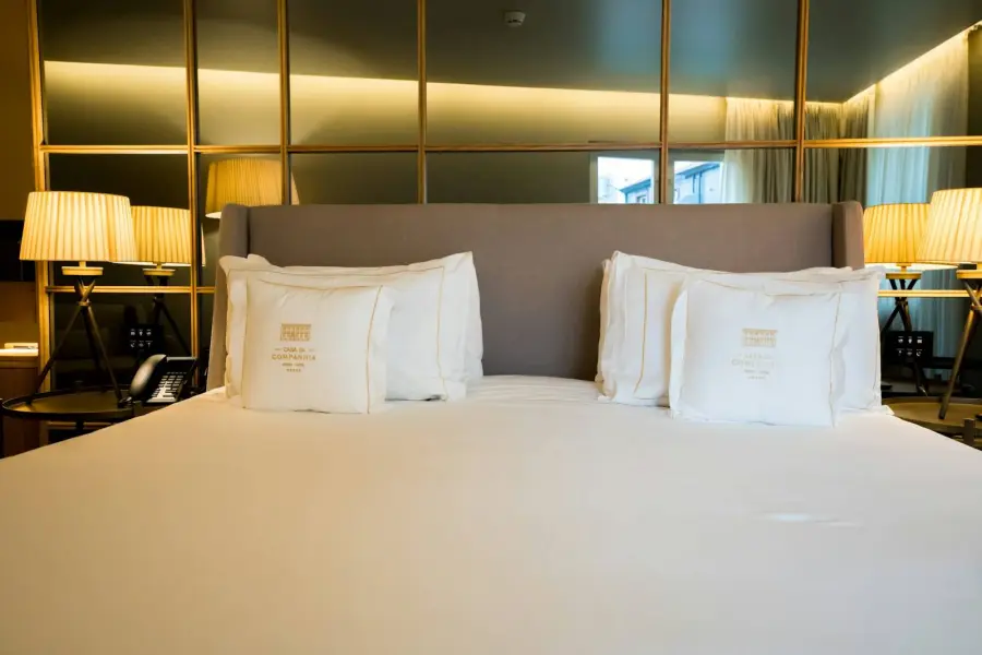 Neatly made bed with lamps
